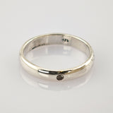 Schlichter Silberring mit abgerundetem Band und dunklem Stein, 925er Punze innen.