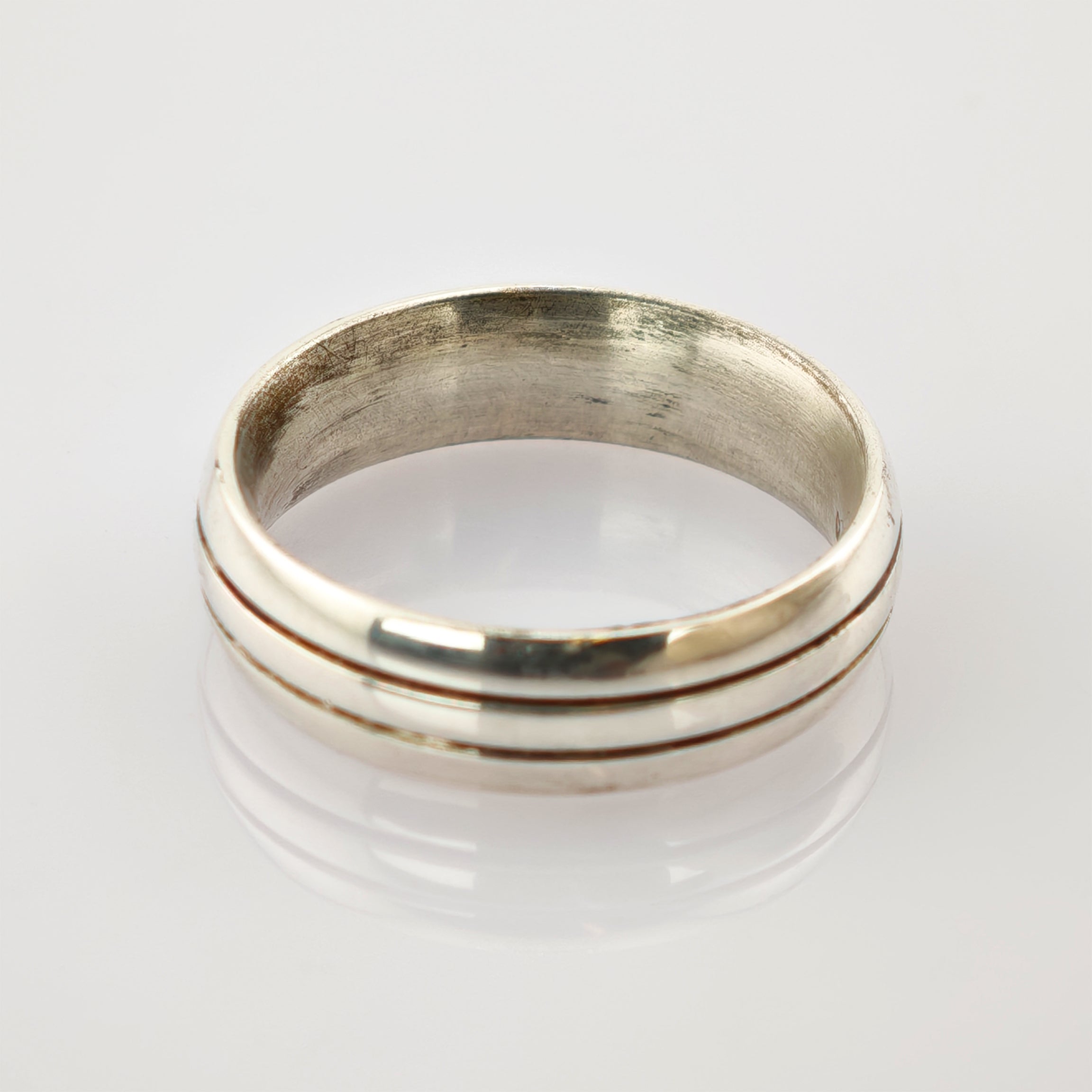 Schlichter Silberring mit zwei parallelen Rillen und leicht matter Oberfläche.
