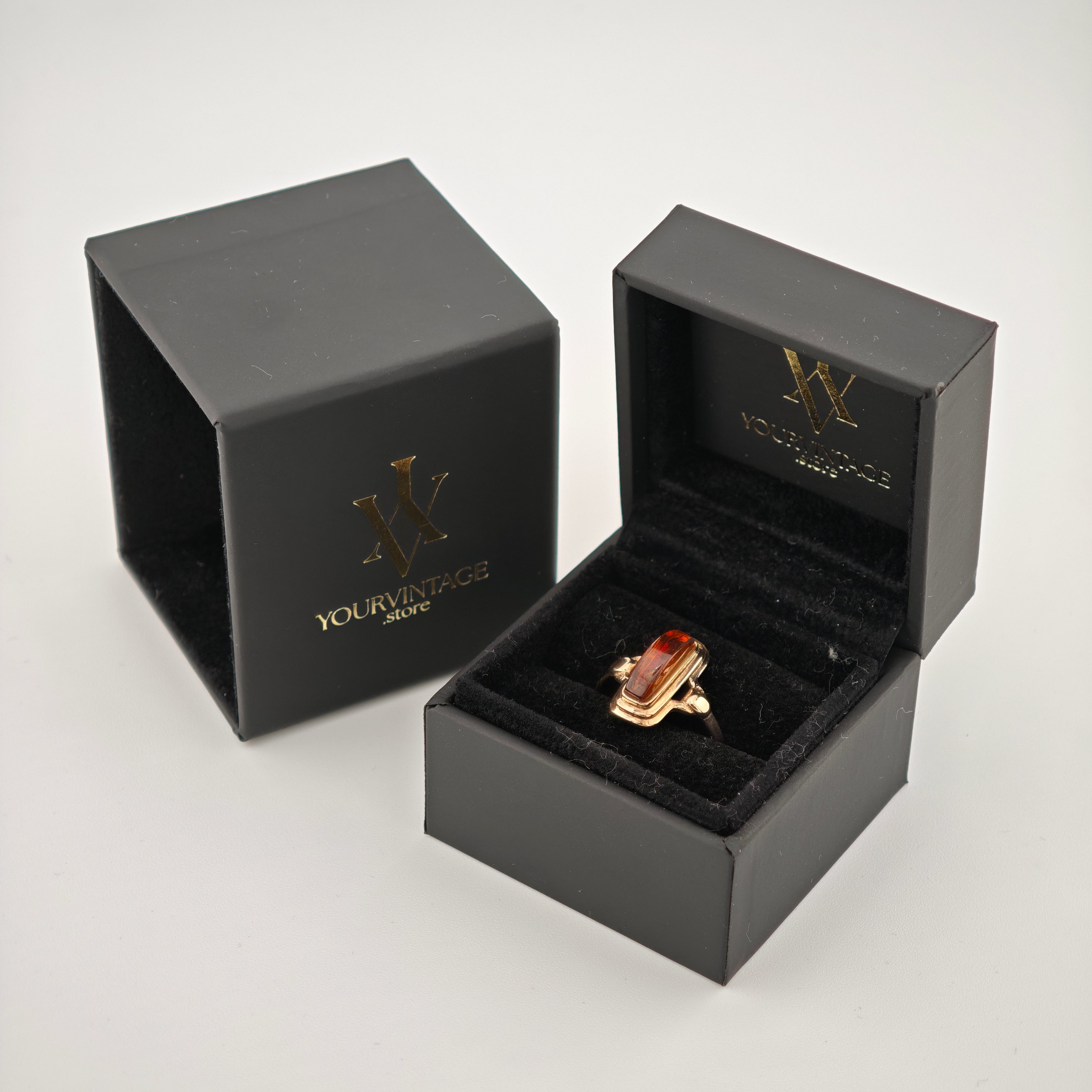 Offene schwarze Schmuckschachtel mit goldfarbenem Ring und bernsteinfarbenem Stein, Markenprägung YOURVINTAGE.store
