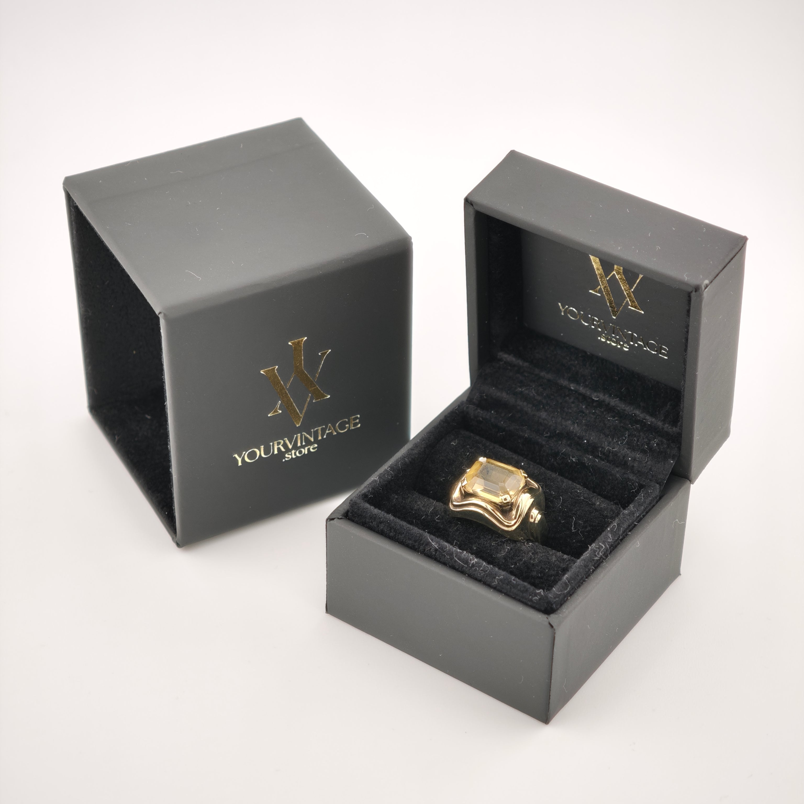 Schwarze Schmuckschachtel mit goldfarbenem Ring und rechteckigem Edelstein, goldenes Logo YOURVINTAGE.store