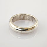 Silberner Bandring mit glänzender, leicht abgenutzter Oberfläche auf weißem Hintergrund