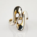 Silberner moderner Ring mit symmetrischen Elementen und polierter Oberfläche vor hellem Hintergrund