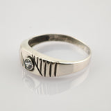 Silberner Ring mit eingraviertem AN VIII Schriftzug und klarem Stein auf reflektierender Oberfläche