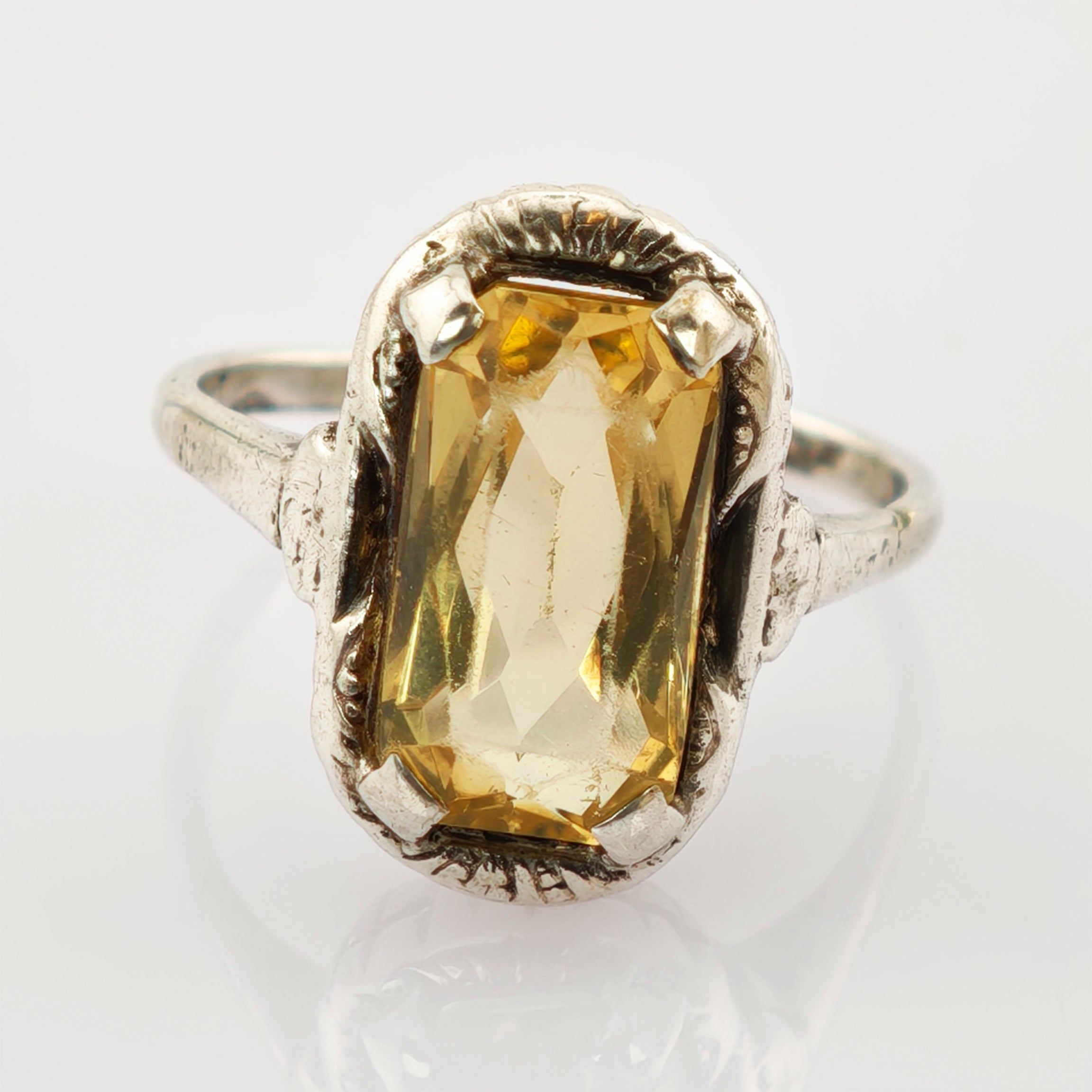 Silberner Ring mit großem rechteckigem gelbem Edelstein in kunstvoller Fassung