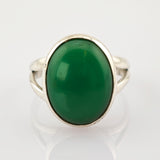 Eleganter silberner Ring mit großem ovalem grünem Edelstein auf weißem Hintergrund.