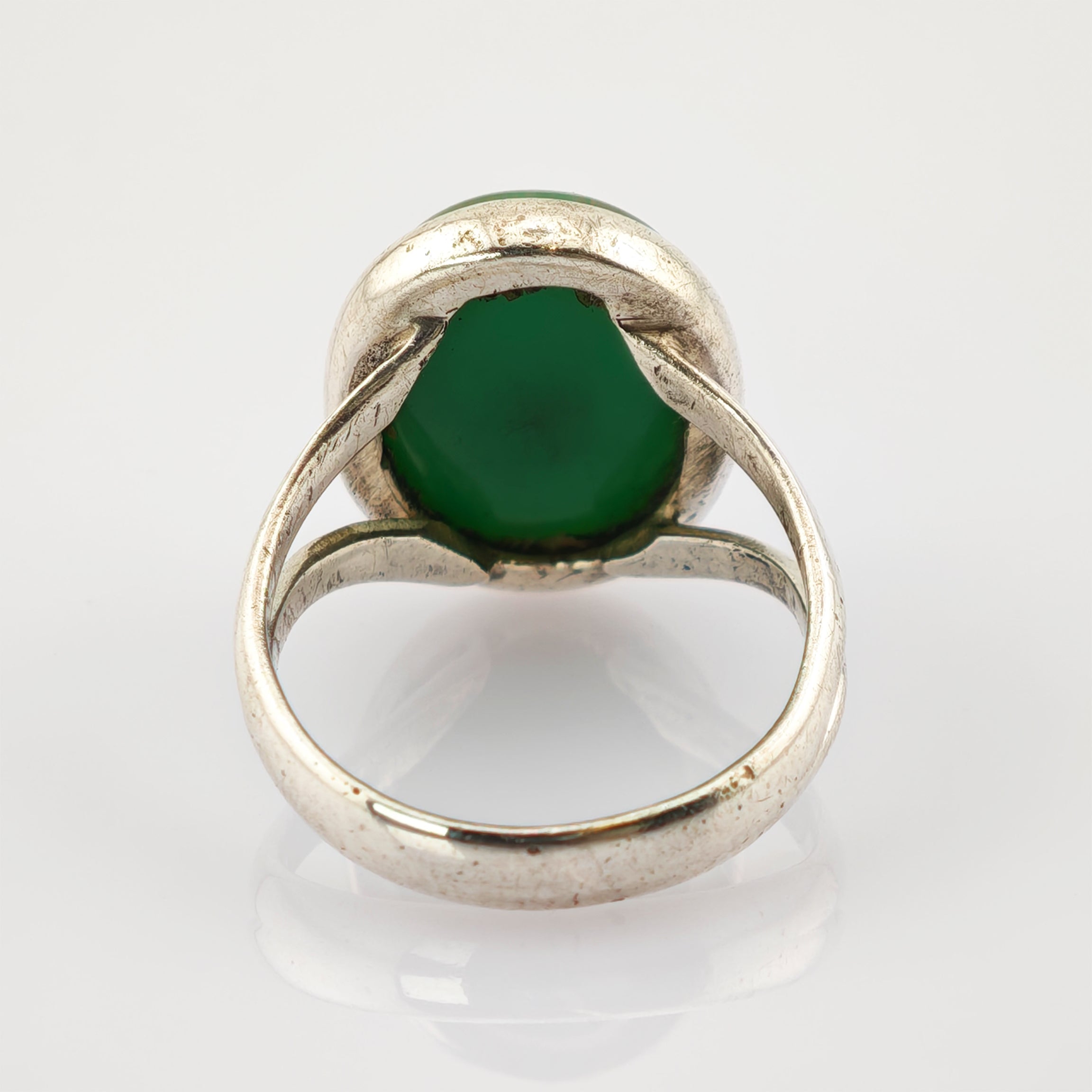 Nahaufnahme eines silbernen Rings mit grünem Stein und Patina, Vintage-Schmuck.