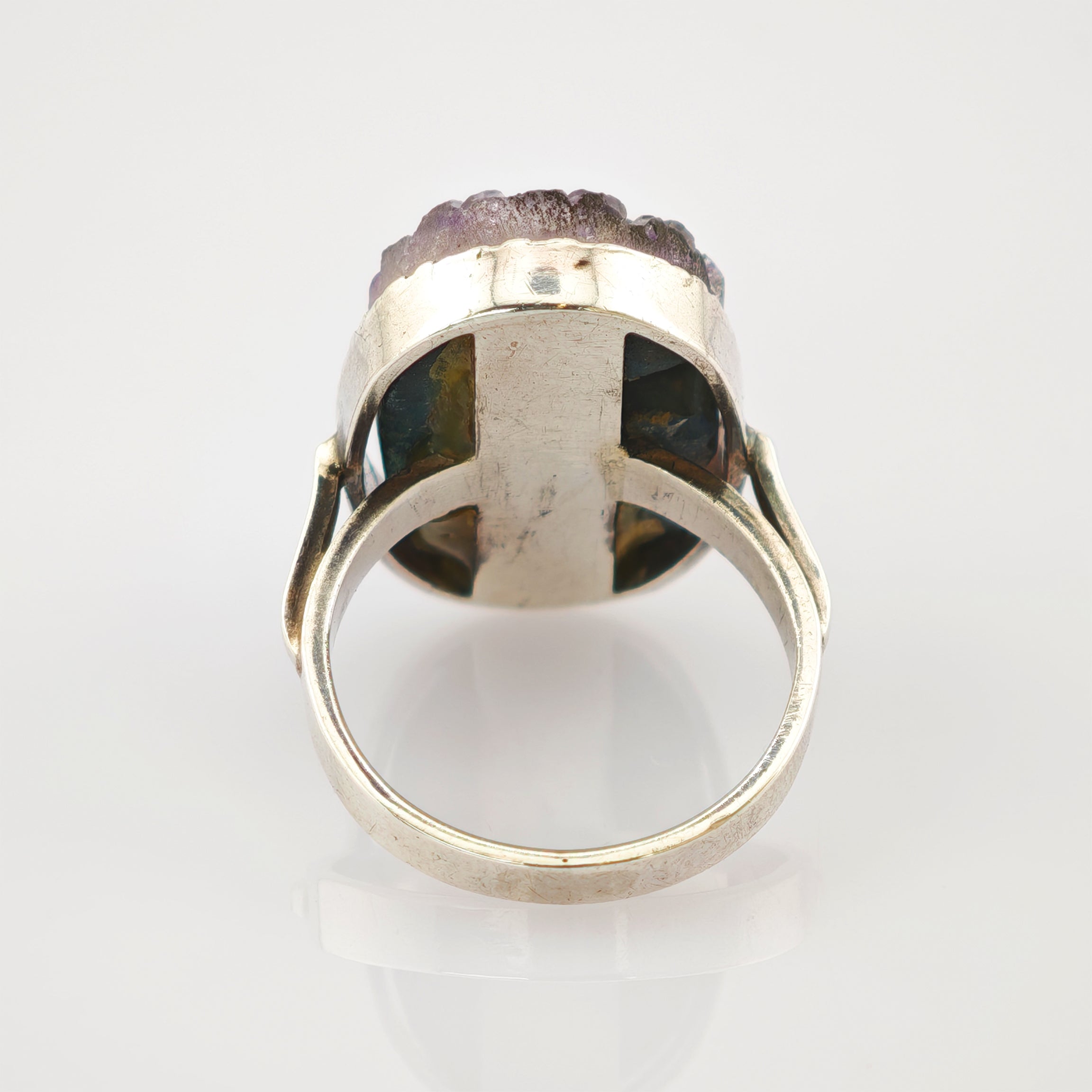 Silberner Ring mit abgerundetem Band und unregelmäßigem lila Edelstein im Setting