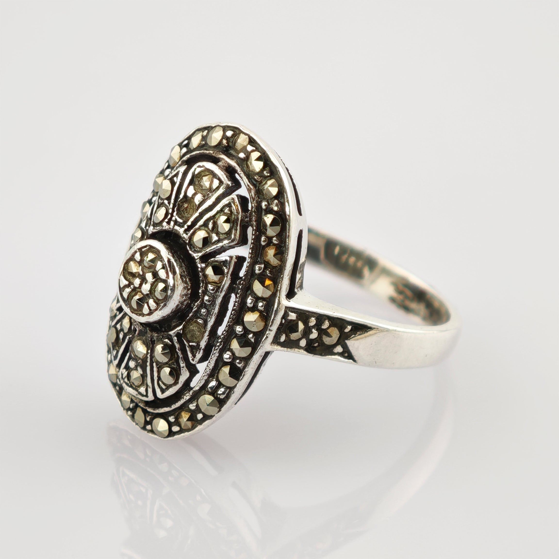 Detailreicher silberner Ring mit ovalem Top, verziert mit kleinen facettierten Steinen in floralem Muster