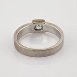 Silberner Ring mit quadratischem, klarem Edelstein und matter Oberfläche.