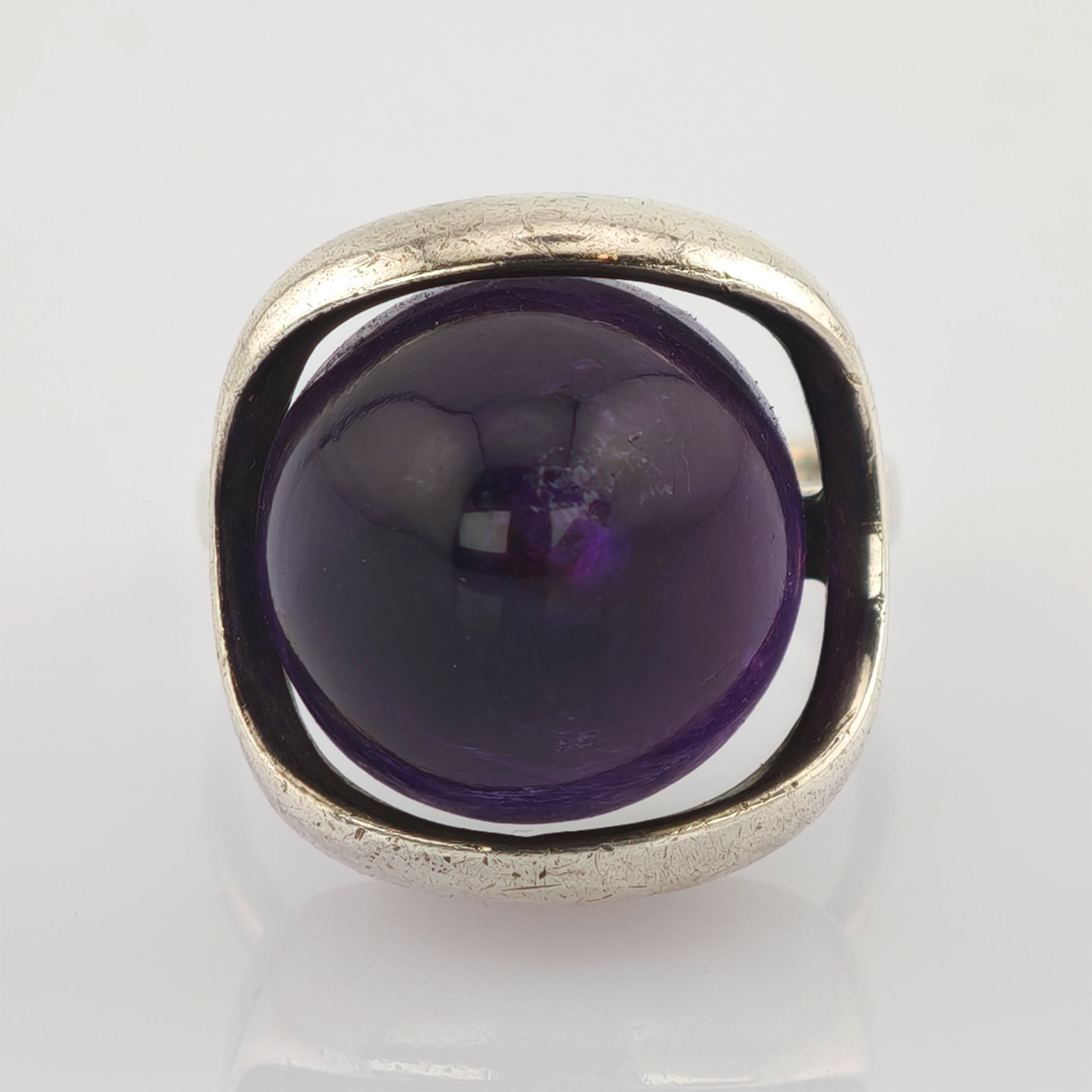 Silberner Ring mit quadratischem Rahmen und großem rundem violetten Stein in der Mitte
