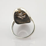 Silberner Ring mit graviertem Vogel-Emblem auf Zweig, oxidiertes Design auf weißem Hintergrund.