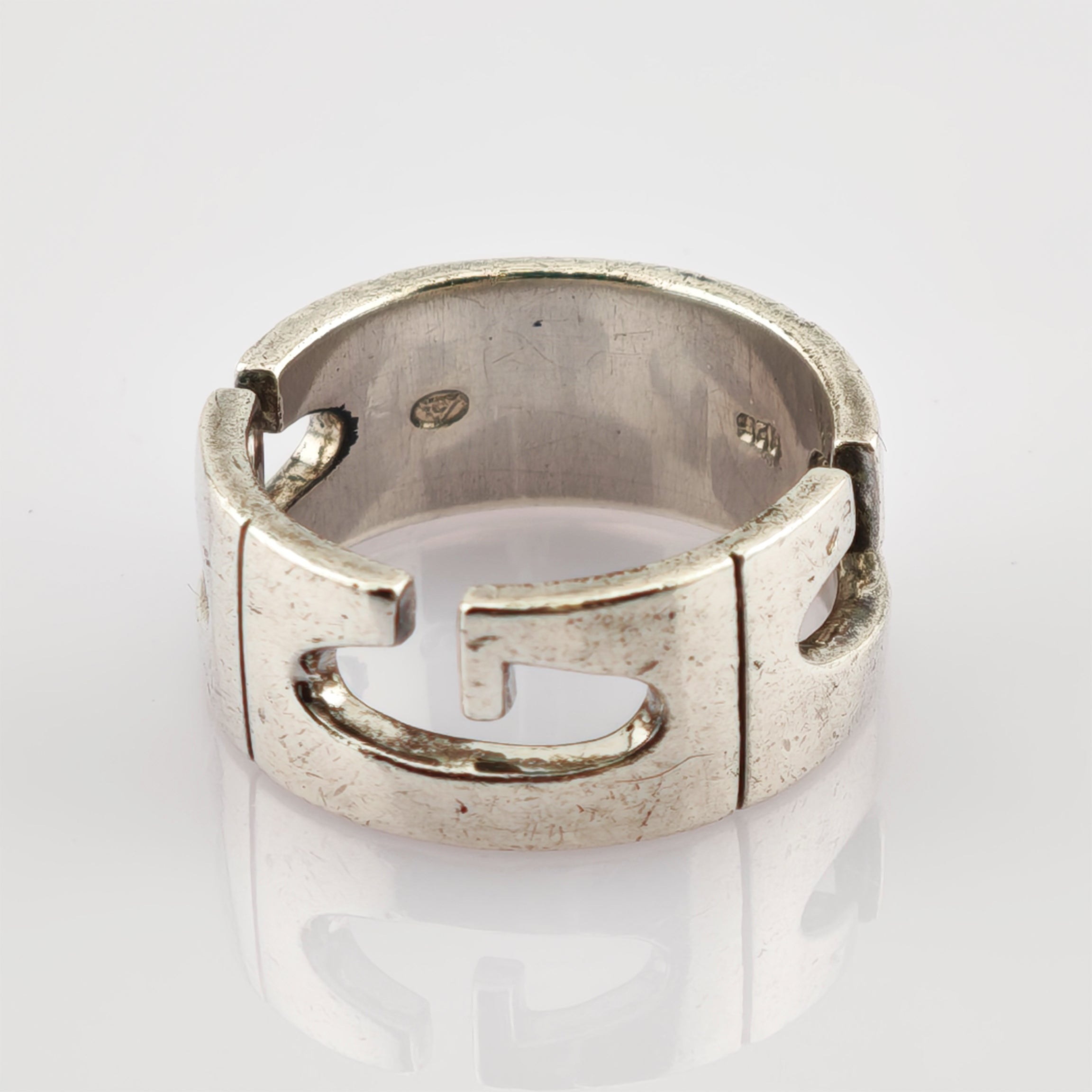 Silberner Vintage-Ring mit ineinandergreifendem Schnittmuster, Größe 12, auf reflektierender weißer Oberfläche.