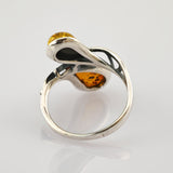 Silberring mit abstraktem Design und zwei bernsteinfarbenen Steinen in geschwungenen, offenen Metallformen