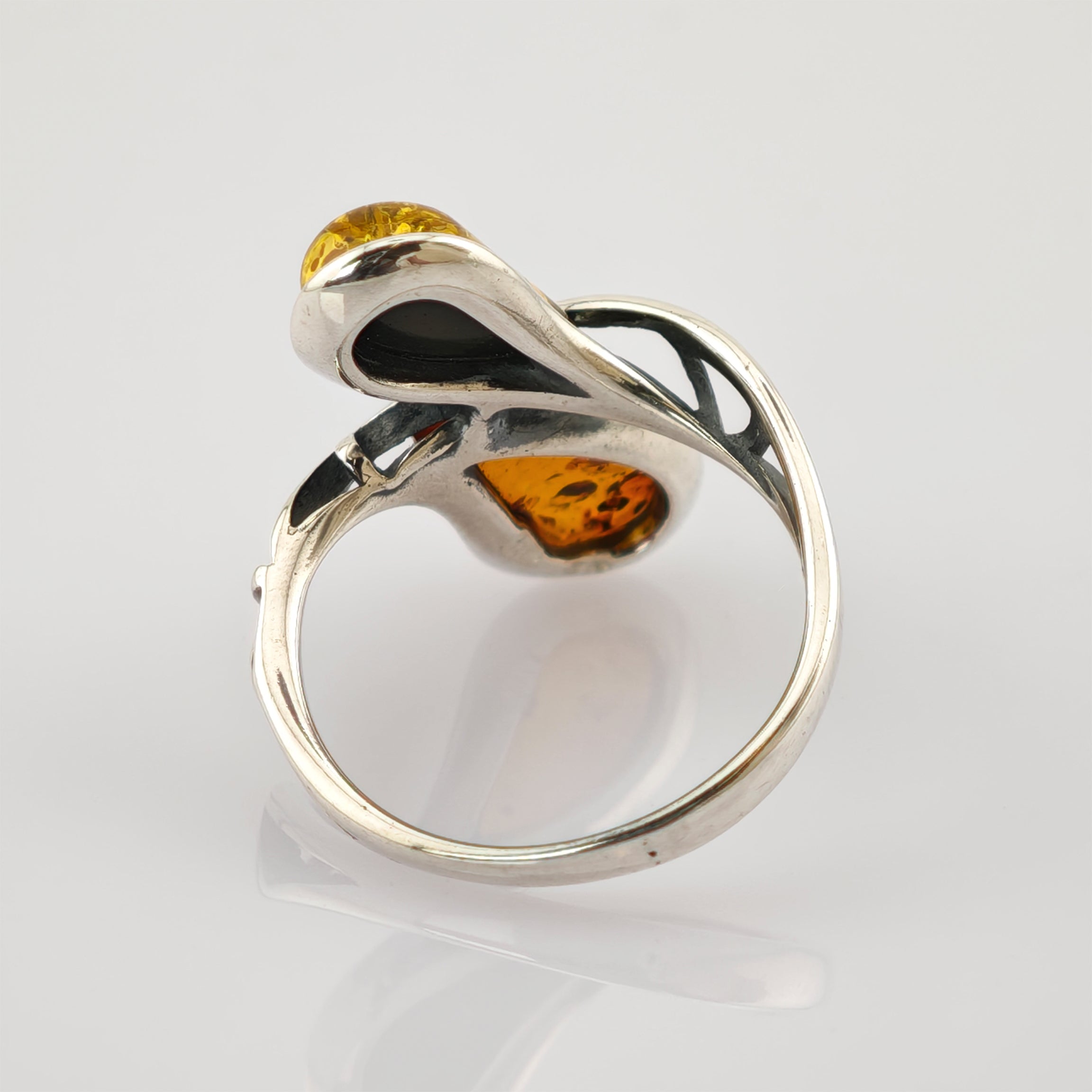 Silberring mit abstraktem Design und zwei bernsteinfarbenen Steinen in geschwungenen, offenen Metallformen