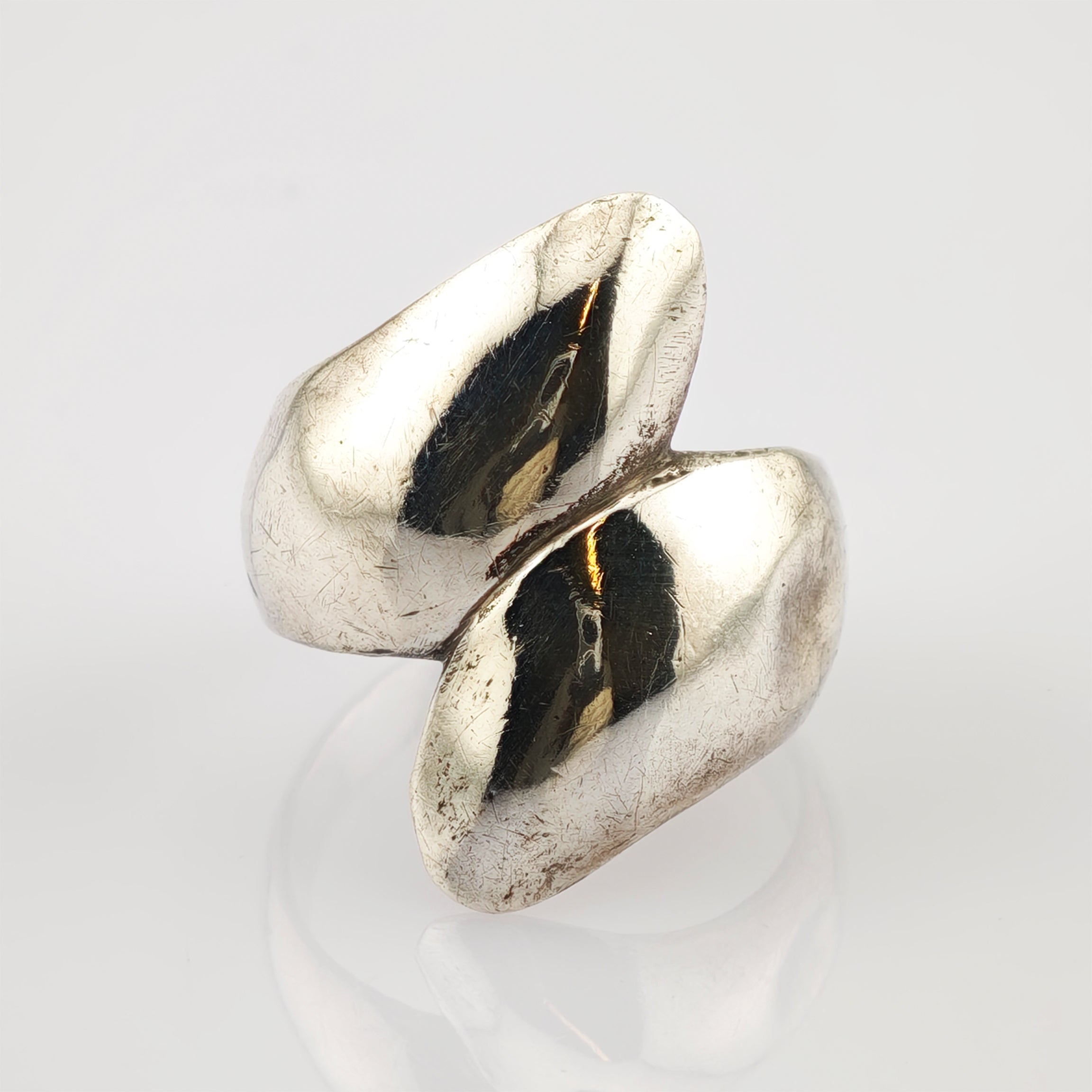 Silberfarbener Ring mit abstraktem Design und polierter Oberfläche mit feinen Gebrauchsspuren