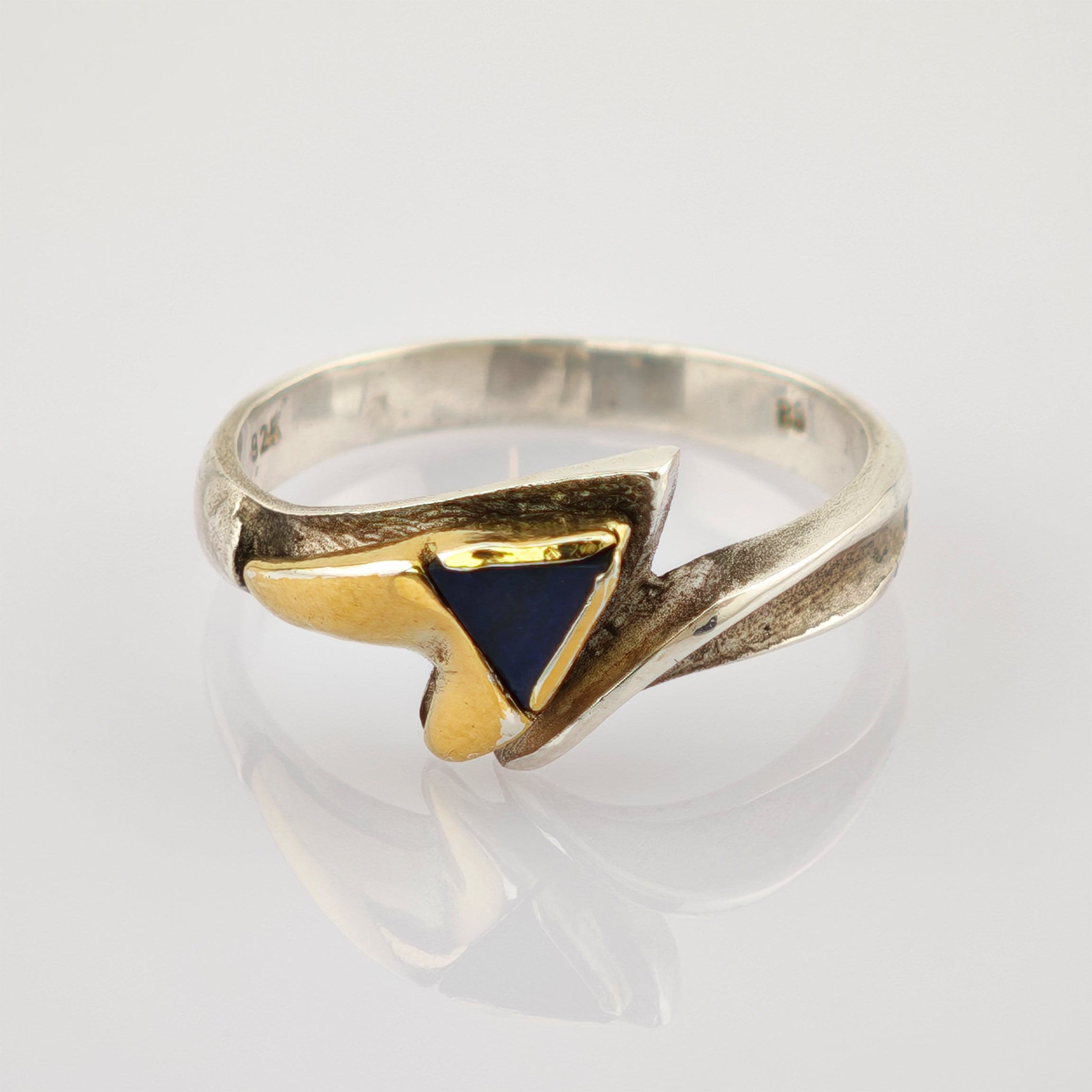 Silberring mit asymmetrischem Design, goldfarbenem Herz und dreieckigem dunkelblauem Stein.