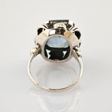 Silberring mit großem blauem Edelstein und filigranem Silberdesign, von oben aufgenommen