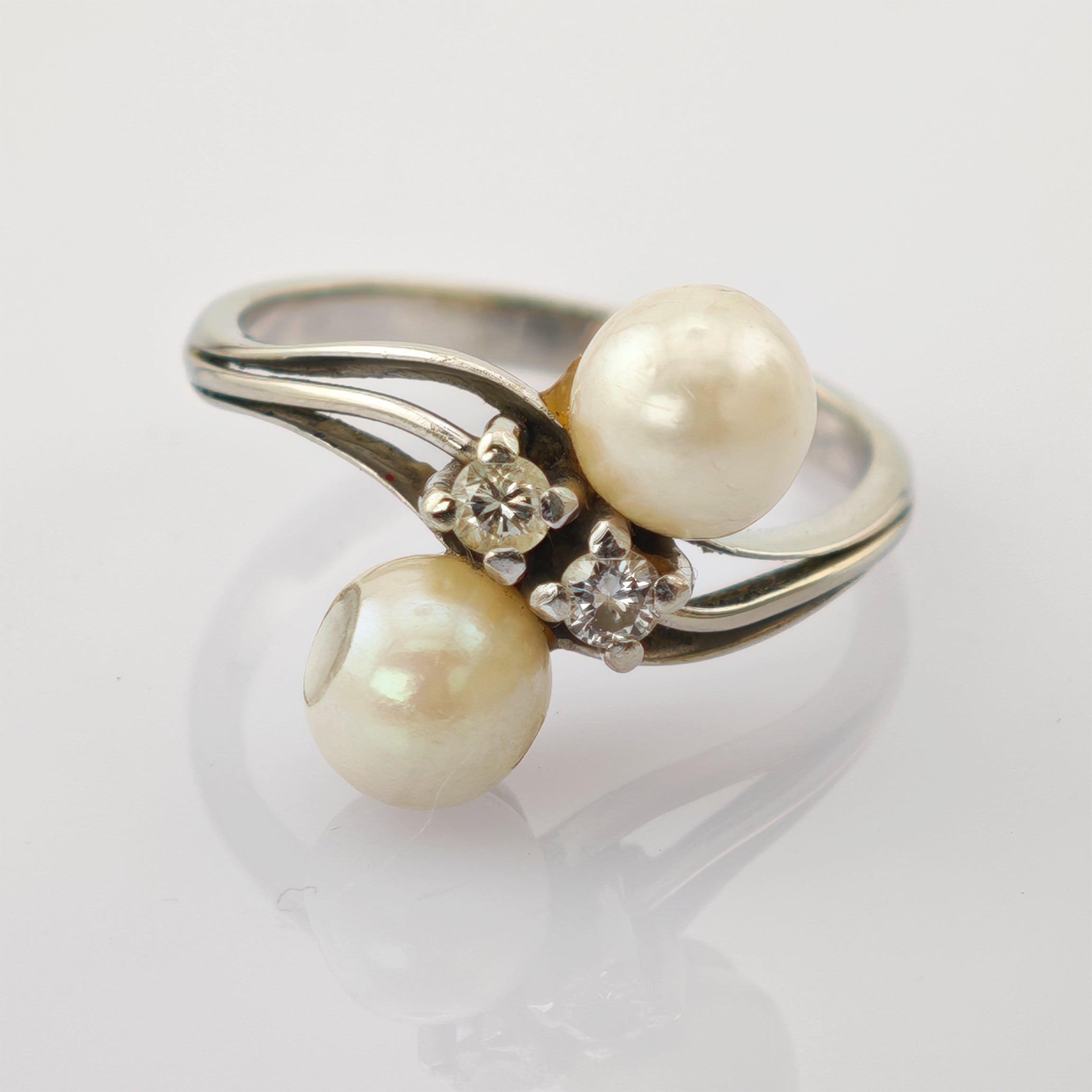 Silberring mit zwei cremefarbenen Perlen und zwei kleinen Diamanten auf geteiltem Band