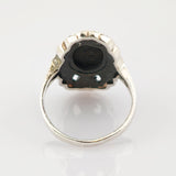 Silberring mit detaillierter Metallarbeit an der Fassung, gezeigt von unten