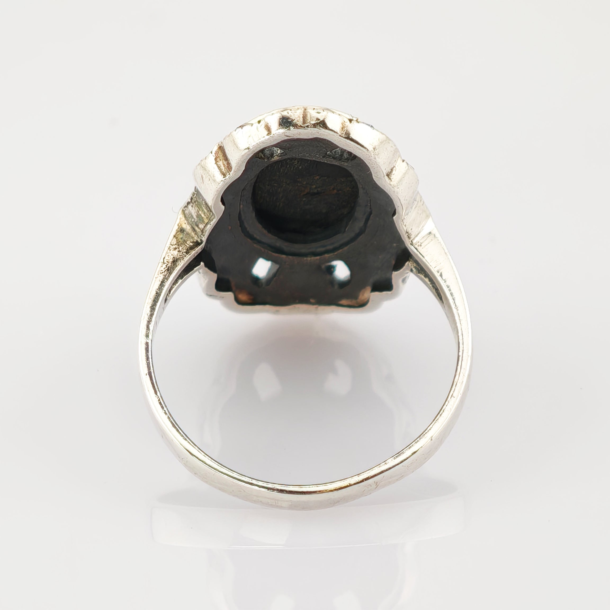 Silberring mit detaillierter Metallarbeit an der Fassung, gezeigt von unten