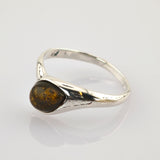 Silberring mit dreieckigem poliertem Bernstein und goldbraunen Einschlüssen auf einem glatten Silberband