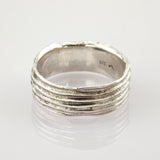 Silberring mit fünf horizontalen Erhebungen und 925er Silberstempel auf reflektierender weißer Oberfläche