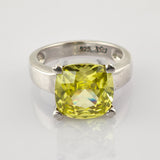 Silberring mit großem kissenförmigem gelbem Edelstein und 925 Silberstempel auf weißem reflektierendem Hintergrund