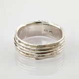 Silberring mit strukturiertem, geripptem Design und 925-Stempel auf reflektierender Oberfläche