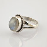 Detaillierter Silberring mit geteiltem Ringband auf reflektierender weißer Oberfläche.