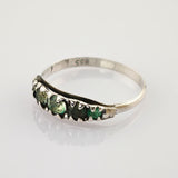 Silberring mit unregelmäßigen grünen Steinen und 835er Punze, auf weißem Untergrund.