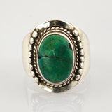 Silberring mit ovalem grünem Edelstein und dekorativen Details.