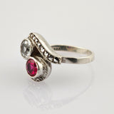 Eleganter Silberring mit großen klaren und roten Edelsteinen auf gewelltem Band mit Metallnieten
