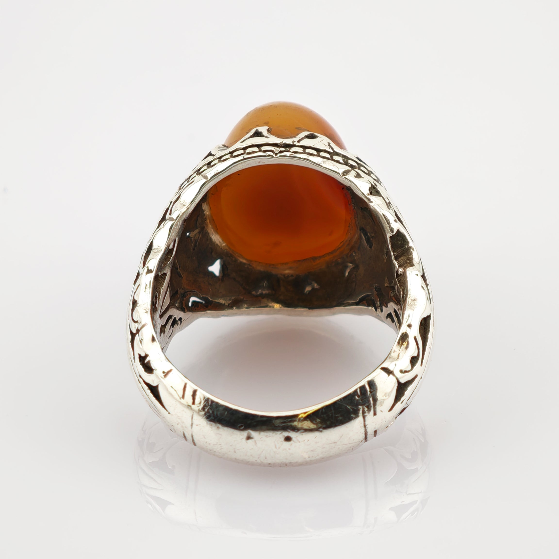 Silberring mit kunstvoll graviertem Band und großem ovalem Bernstein im Fassungsring