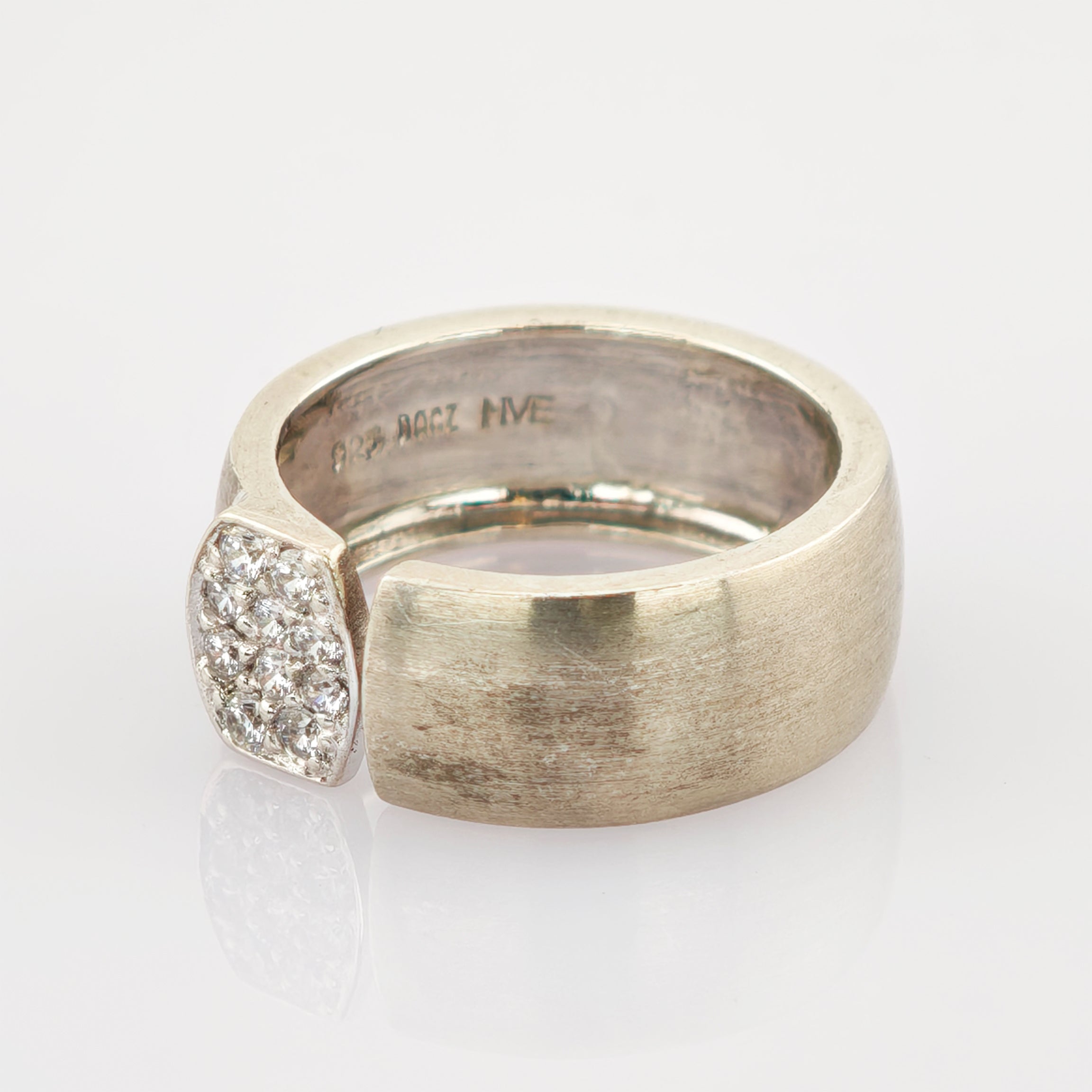 Silberfarbener Ring mit breitem Band und strukturiertem Oberfläche mit Edelsteinen