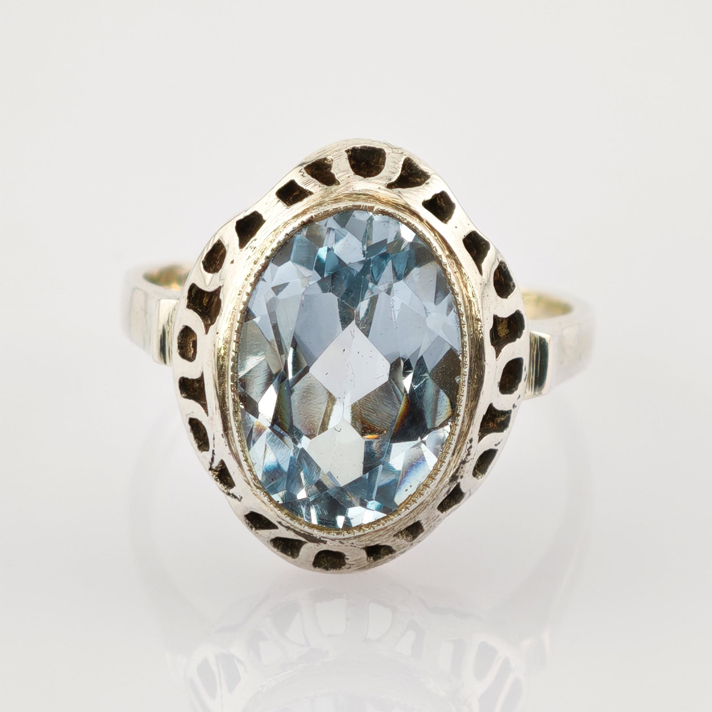 Silberring mit ovalem blauen Edelstein und kunstvollen Ausschnitten am Band