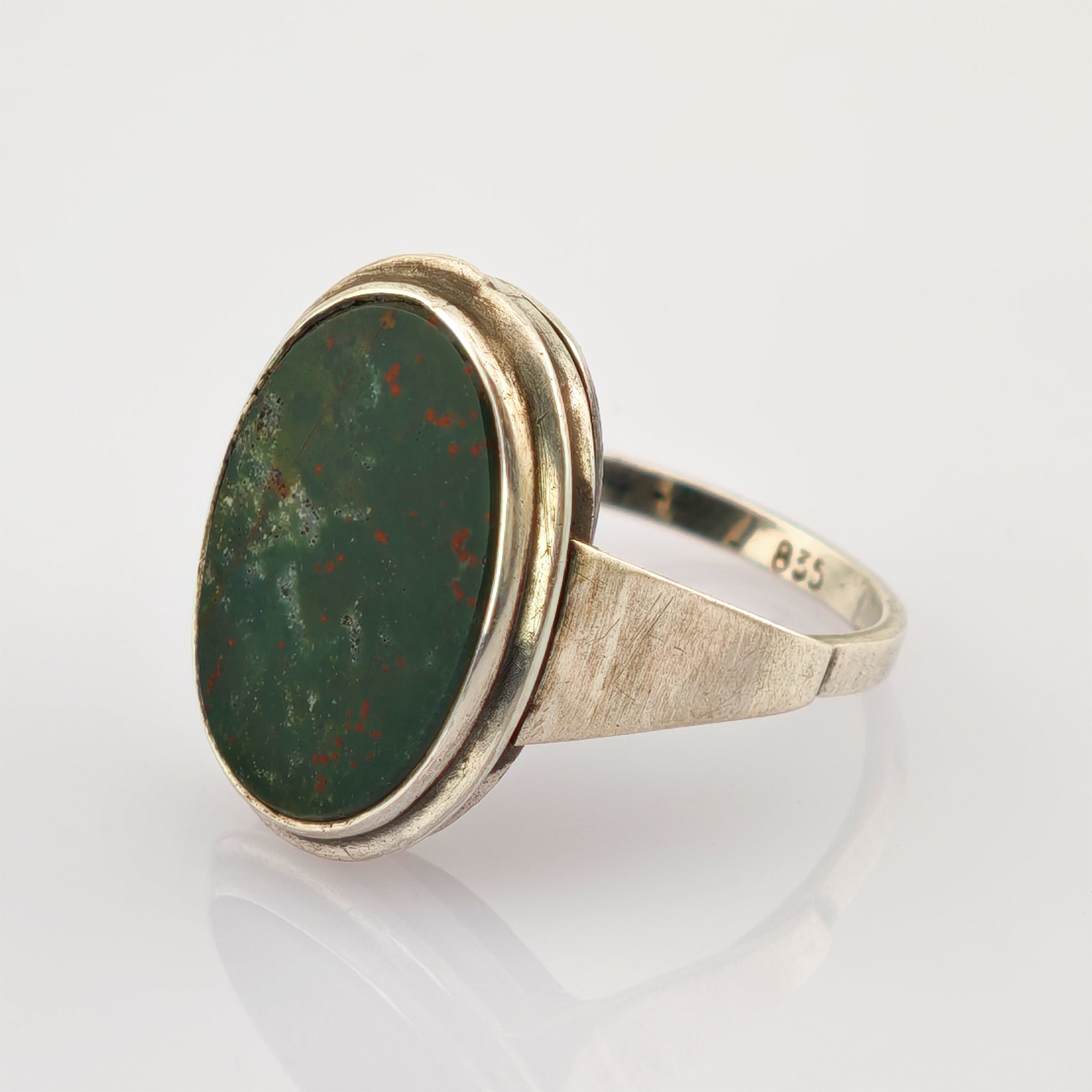 Silberring mit ovalem grünem Stein und roten Sprenkeln, schlichtes Design, 835er Punze.