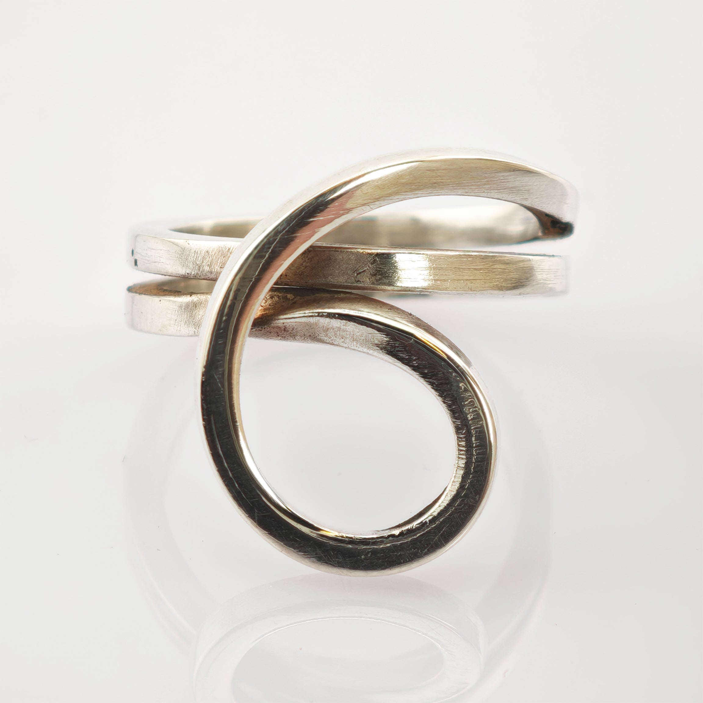 Silberner Ring mit künstlerischem Spiralschleifendesign und glattem Finish.