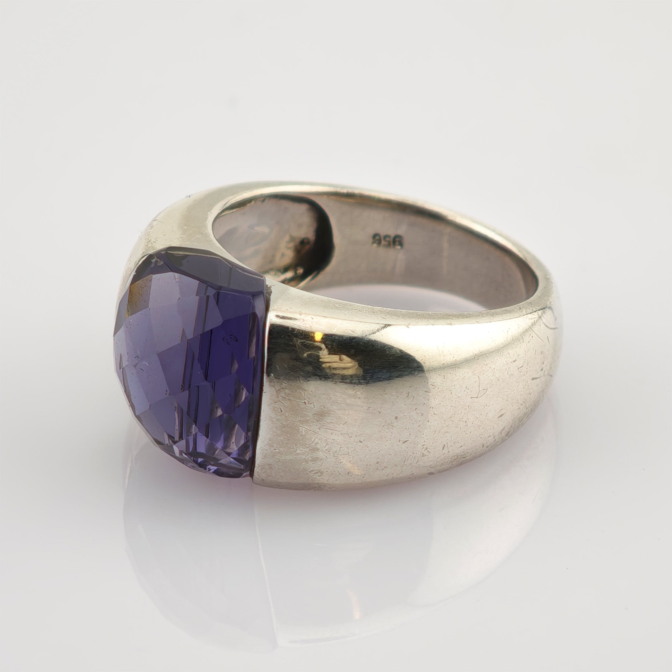 Silberring mit großem facettiertem violettem Edelstein auf reflektierender weißer Oberfläche mit sichtbarem 925 Stempel