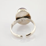 Verstellbarer Silberring mit rundem Amethyst und sichtbaren Kratzern.