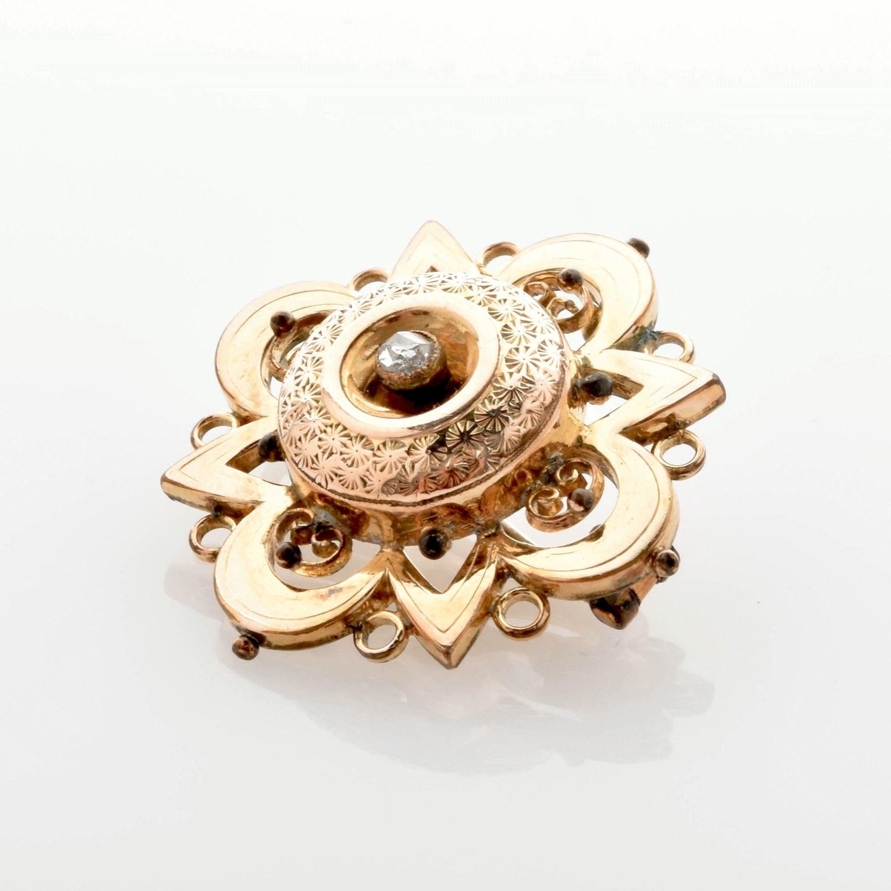 Verzierte Vintage-Goldbrosche mit zentralem, diamantähnlichem Stein und floralen Mustern