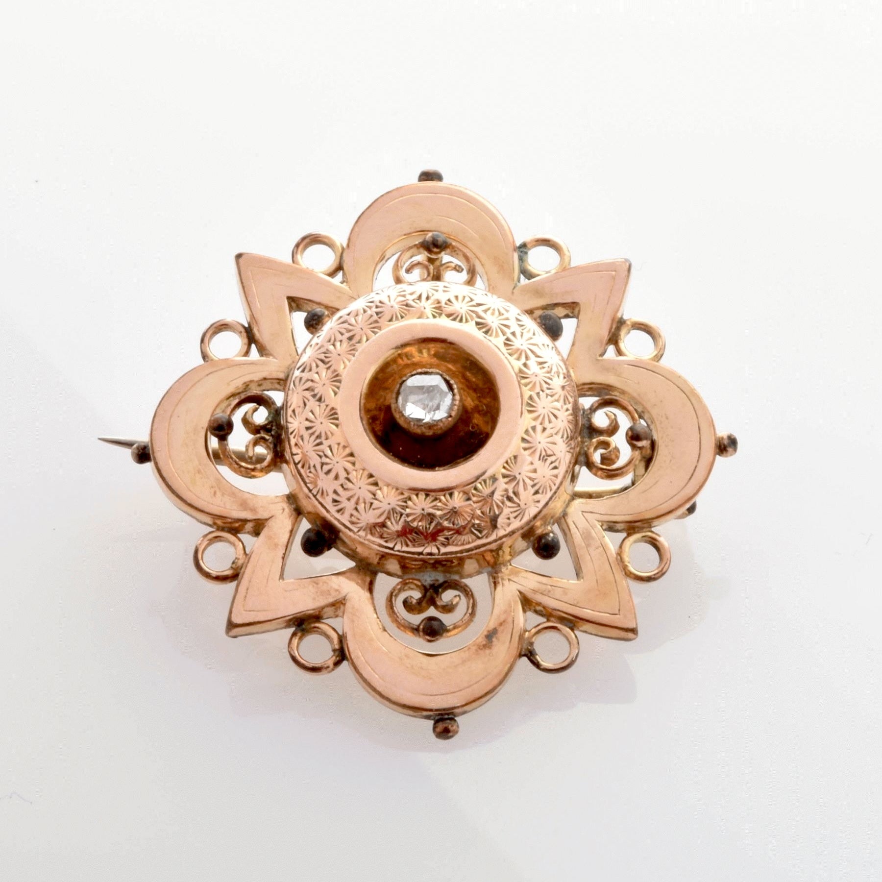 Verzierte Vintage-Goldbrosche mit zentralem, diamantähnlichem Stein und floralen Mustern