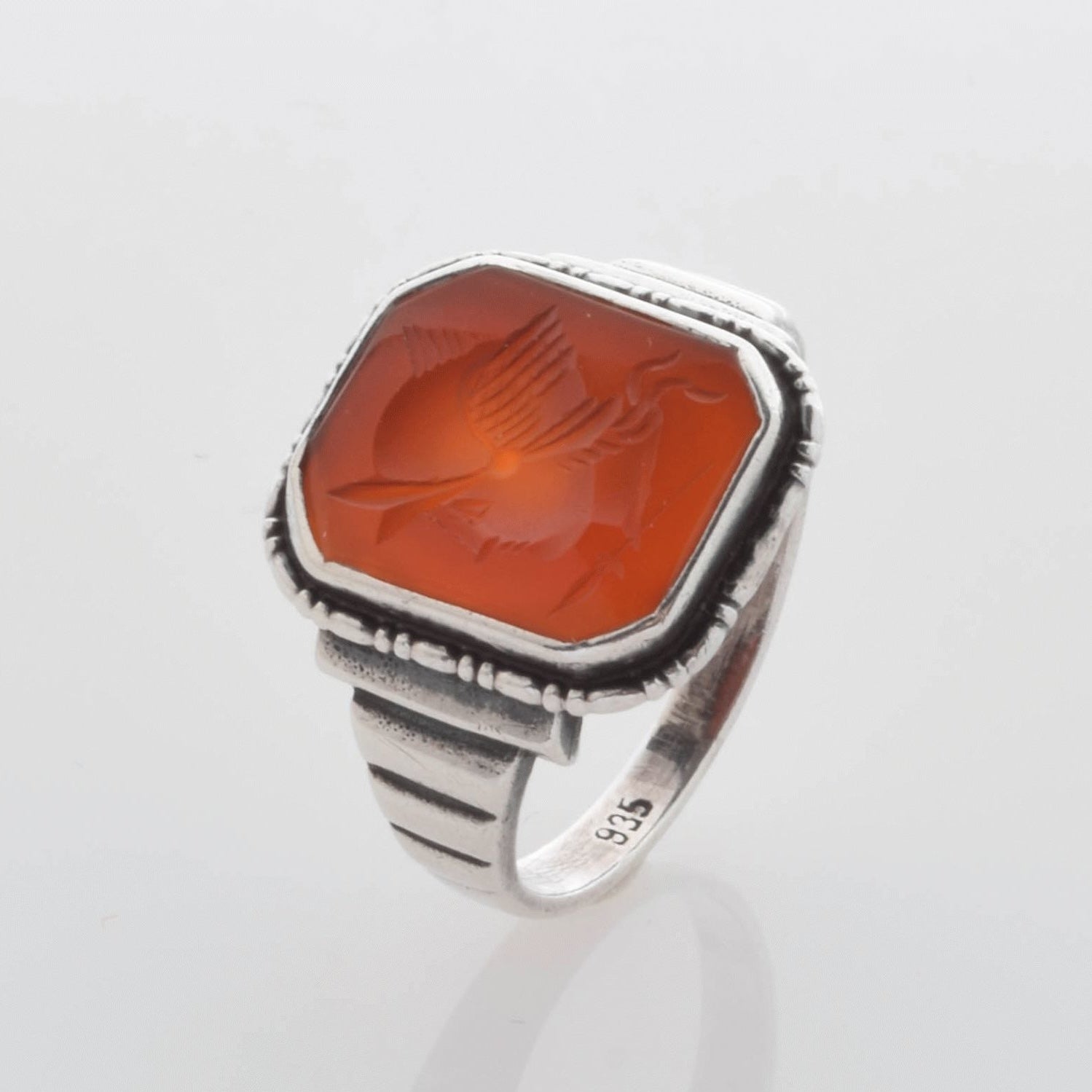 Vintage-Silberring mit breitem Band und hexagonalem orangefarbenem Stein und geätztem Flügelmuster.