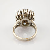 Vintage Silberring mit erhabener Fassung und funkelnden Steinen im dekorativen Clusterdesign.