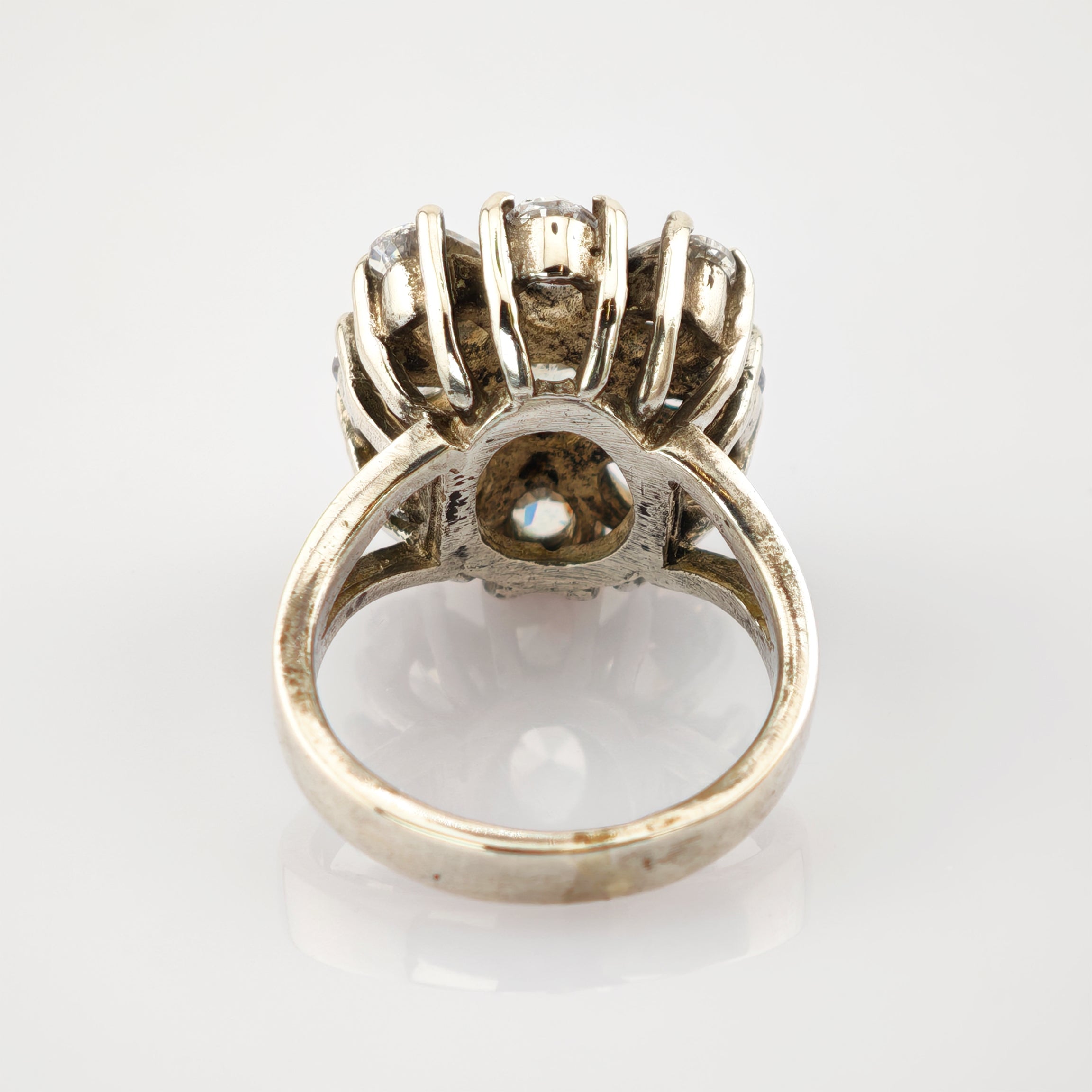 Vintage Silberring mit erhabener Fassung und funkelnden Steinen im dekorativen Clusterdesign.