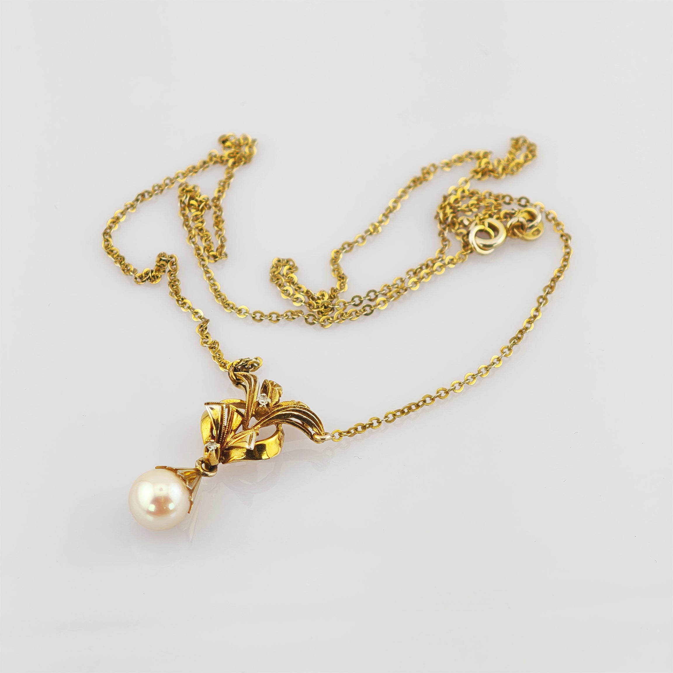 Zartes Goldkettchen mit elegantem Anhänger und großem weißen Perltropfen.