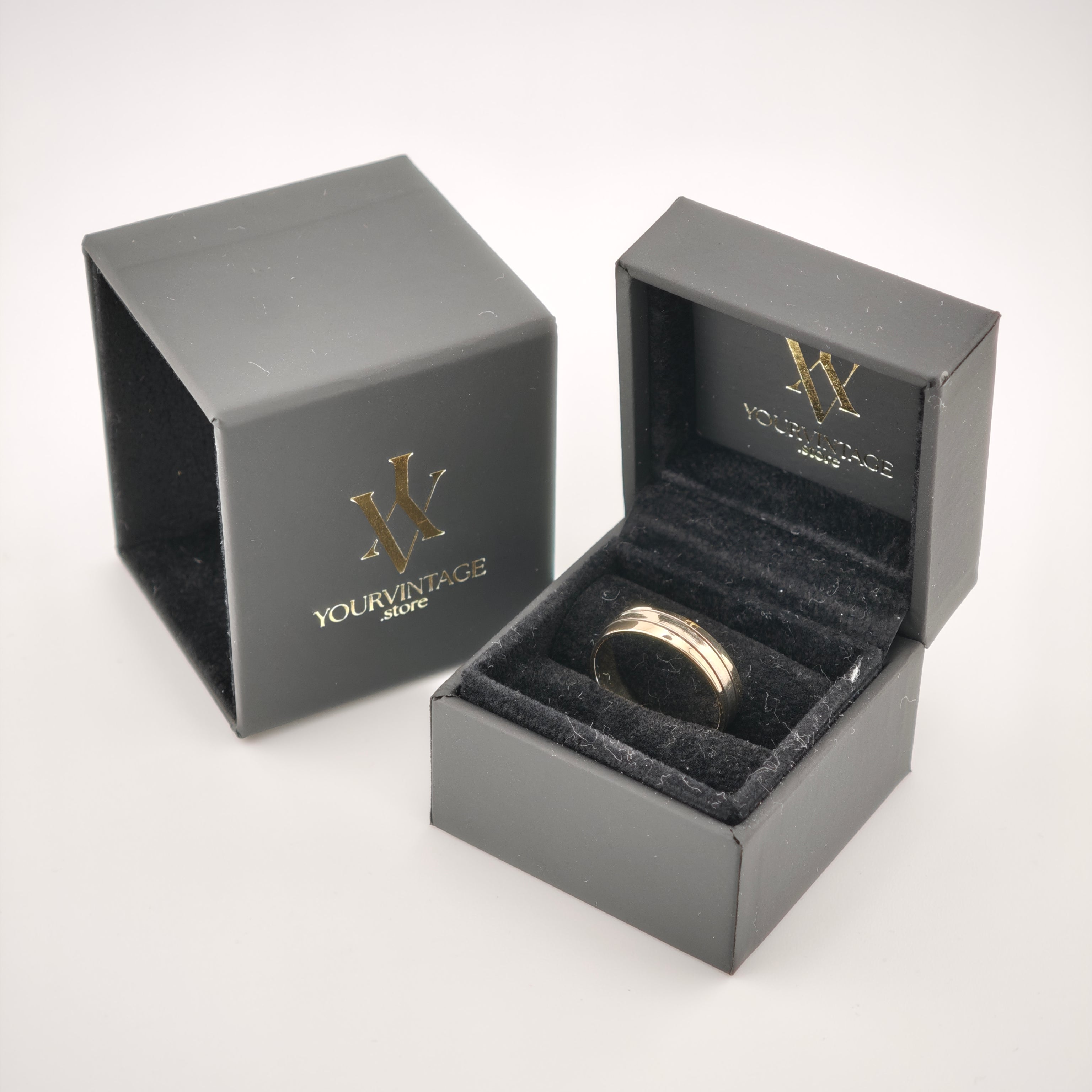 Zwei elegante schwarze Ringboxen mit goldfarbenem YOURVINTAGE.store Logo, eine geöffnet mit goldenem Ring auf schwarzem Samt