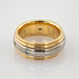 Zweisilberner Ring mit goldenem Innenring und zwei kleinen runden klaren Edelsteinen auf weißem Hintergrund