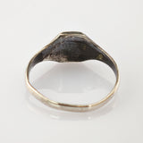 Nahaufnahme eines alten Metallrings mit Kratzern und Abnutzungsspuren an der Innenfläche.