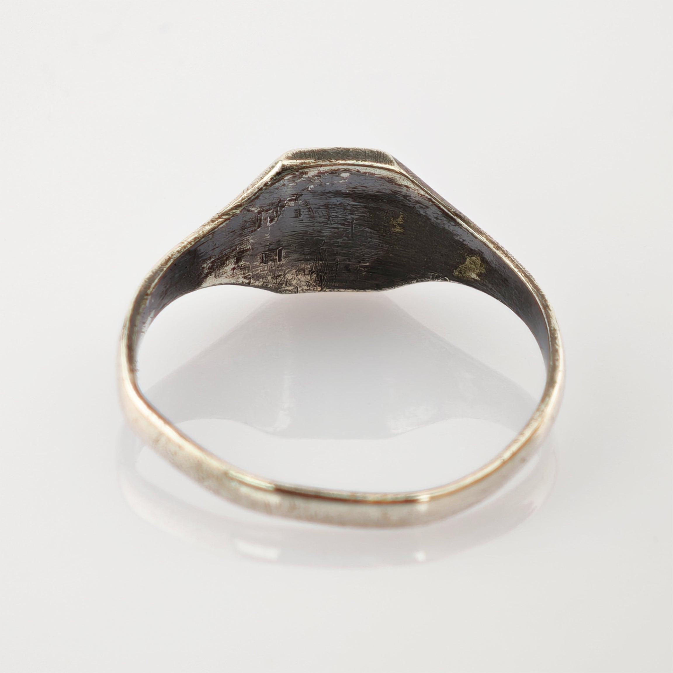 Nahaufnahme eines alten Metallrings mit Kratzern und Abnutzungsspuren an der Innenfläche.