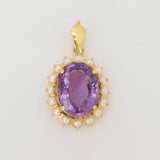Anhänger mit facettiertem ovalem lila Edelstein und weißen Perlen im goldenen Rahmen
